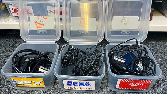 video game console cords stored in labeled storage bins